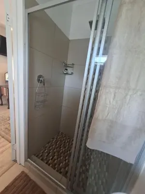a shower with a glass door in a bathroom at 28 on Old Farm in Cape Town