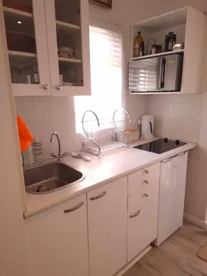 a kitchen with white cabinets and a sink and a window at 28 on Old Farm in Cape Town