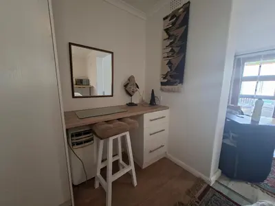 a bathroom with a desk with a mirror and a stool at 28 on Old Farm in Cape Town