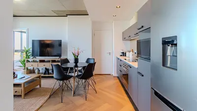 a kitchen and living room with a table and chairs at Bridgewater Serenity Collection 708 in Cape Town