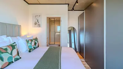 a bedroom with a large white bed with pillows at Bridgewater Serenity Collection 708 in Cape Town