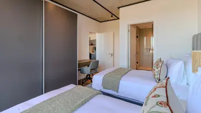 a hotel room with two beds and a desk at Bridgewater Serenity Collection 708 in Cape Town