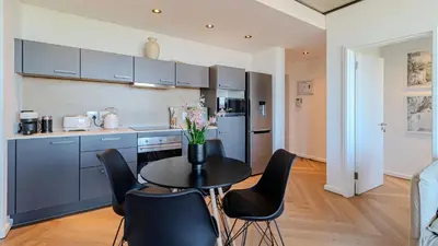 a kitchen with a black table and chairs in a room at Bridgewater Serenity Collection 708 in Cape Town
