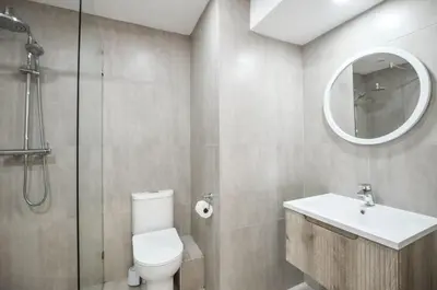 a bathroom with a toilet and a sink and a mirror at 2 Bedroom Apartment - Dolphin Beach in Cape Town