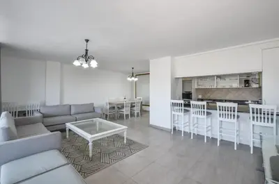 a living room with a couch and a table and a kitchen at 2 Bedroom Apartment - Dolphin Beach in Cape Town