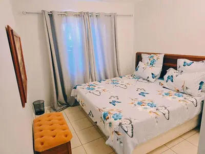 a bedroom with a bed with blue flowers on it at Blouberg 2 bedroom apartment in Cape Town