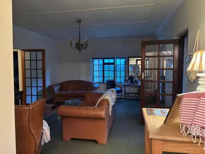 a living room with a couch and chairs and a table at Hermanus Hartshuis in Hermanus