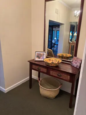 a bathroom with a vanity with a mirror and a table at Hermanus Hartshuis in Hermanus