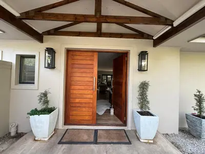 a front door of a house with two potted plants at 10onErika Franschhoek in Franschhoek