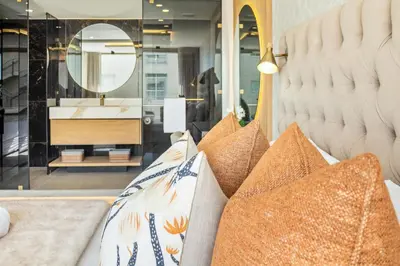 a store with pillows on a bench with a mirror at Lagoon Beach Luxe 116A in Cape Town
