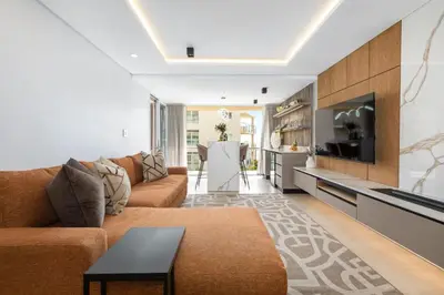 a living room with a couch and a table at Lagoon Beach Luxe 116A in Cape Town