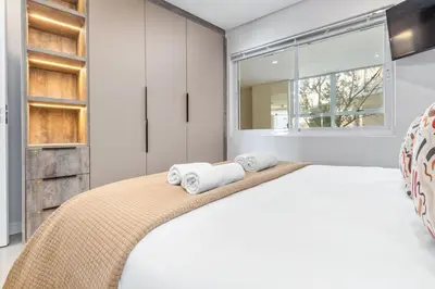 a bedroom with a large bed with towels on it at Lagoon Beach Luxe 116A in Cape Town