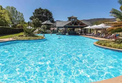a large pool with blue water in front of a house at Luxury Lodge TheView, Pearl Valley Golf Estate in Paarl