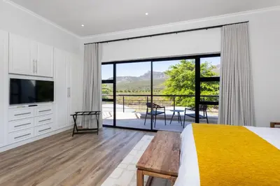 a bedroom with a bed and a sliding glass door at Luxury Lodge TheView, Pearl Valley Golf Estate in Paarl