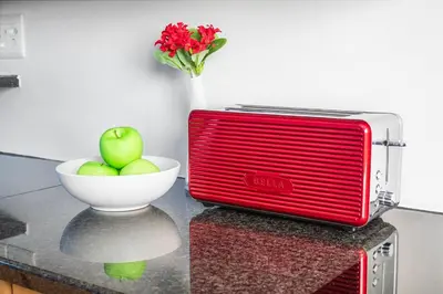 a red toaster sitting on a counter with a bowl of apples at La Savina The Island Club in Cape Town