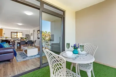 a living room with a table and chairs at La Savina The Island Club in Cape Town