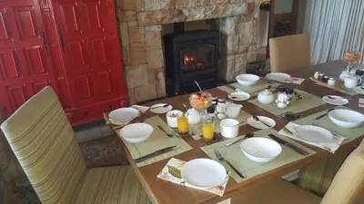 a table with plates and bowls on it with a fireplace at 43 On Sandstone in Somerset West