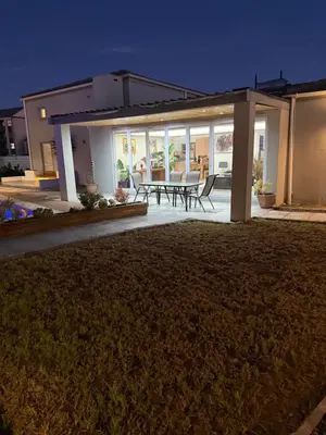 a backyard of a house with a table and chairs at Parklands Family Stay in Cape Town