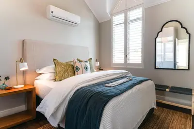 a bedroom with a large bed and a mirror at Luxury Villa in Best Central Location in Franschhoek