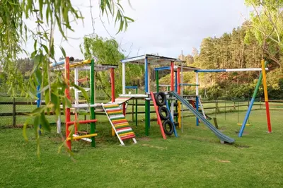 a playground with colorful play equipment in a park at Houw Hoek Hotel in Botrivier