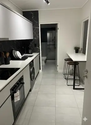 a kitchen with white counters and a table in it at Cosy spot in Blackheath