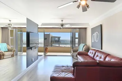 a living room with a couch and a table at Beautiful Views - Lagoon Beach 2 Bed Apartment in Cape Town