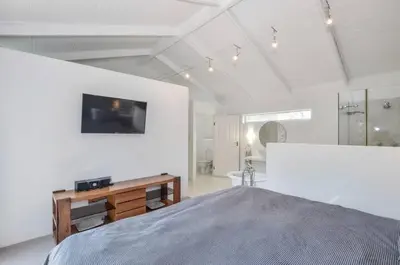 a large white room with a bed and a desk at Large 4 Bedroom Villa with Pool in Cape Town