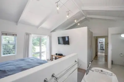 a bedroom with a bed and a tub and a sink at Large 4 Bedroom Villa with Pool in Cape Town