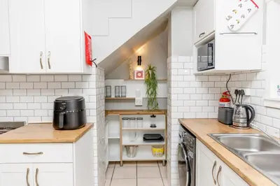 a kitchen with white cabinets and a sink at Home in Durbanville in Oakdale