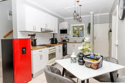 a kitchen with a table and a red refrigerator at Home in Durbanville in Oakdale