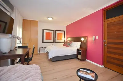 a bedroom with a bed and a pink wall at The Sleep Easy in the Old Town Stellenbosch in Stellenbosch