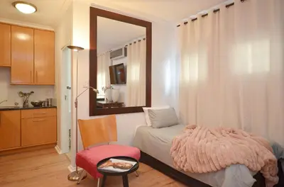 a bedroom with a bed and a mirror and a chair at The Sleep Easy in the Old Town Stellenbosch in Stellenbosch