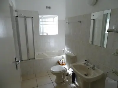 a bathroom with a toilet and a sink at Big Skies Guesthouse in Gordonʼs Bay