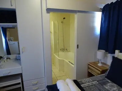 a bathroom with a shower and a bathroom with a sink at Big Skies Guesthouse in Gordonʼs Bay