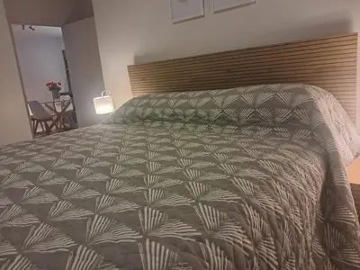 a bedroom with a large bed with a brown and white comforter at Salt & Sandy Shores Dolphin Beach Blouberg in Cape Town