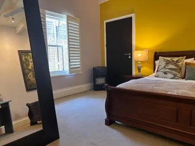 a bedroom with a bed and a window at Bishopsfield Guesthouse Rondebosch in Cape Town
