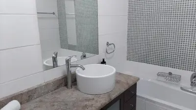 a white bathroom with a sink and a tub at Nice Views in Cape Town