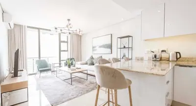 a kitchen and living room with a counter and chairs at Andringa Walk, Modern 2 Bedroom Apartment in Stellenbosch