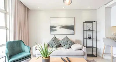 a living room with a couch and a chair at Andringa Walk, Modern 2 Bedroom Apartment in Stellenbosch