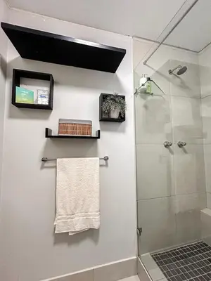 a bathroom with a shower and a towel at The Hideaway on Moringa Way in Cape Town