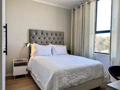 a bedroom with a large bed and a window at The Hideaway on Moringa Way in Cape Town