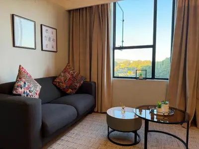 a living room with a couch and a table and a window at The Hideaway on Moringa Way in Cape Town