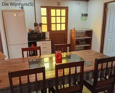 a kitchen with a large wooden table and chairs at Groendraai PetFriendly SelfCatering Accommodation, Die Karoohuis, Die Wijnhuis and Die Vinknes