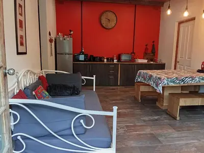 a kitchen with red walls and a dining room with a table at Groendraai PetFriendly SelfCatering Accommodation, Die Karoohuis, Die Wijnhuis and Die Vinknes