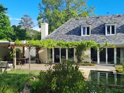 a house with a garden and a swimming pool at Tranquil Stylish Home with Nature Pool near Reserve in Somerset West