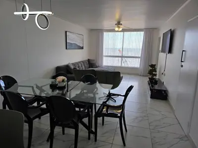 a dining room and living room with a glass table and chairs at 607 Odean - Luxury Ocean Escape in Strand