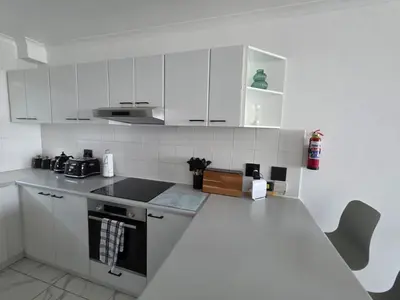 a kitchen with white cabinets and a counter top at 607 Odean - Luxury Ocean Escape in Strand