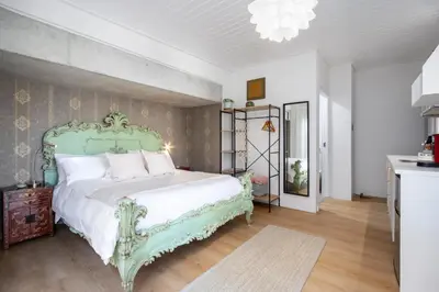 a bedroom with a green bed with white pillows at House Indlovu in Hermanus