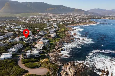 an aerial view of the coast with a red marker at House Indlovu in Hermanus