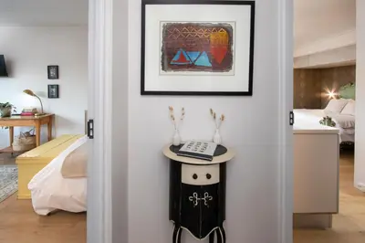 a room with a bed and a table with a phone on it at House Indlovu in Hermanus